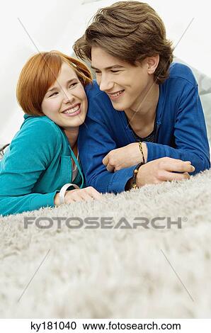 Close-up of a young woman with a teenage boy lying on a carpet and smiling View Large Photo Image Stock Image - Close-up of a young woman with a teenage boy lying on a carpet and smiling. Fotosearch