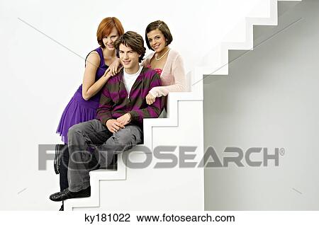 Portrait of a teenage boy sitting on steps with two young women and smiling View Large Photo Image Stock Image - Portrait of a teenage boy sitting on steps with two young women and smiling. Fotosearch