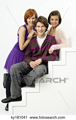 Portrait of a teenage boy sitting on steps with two young women and smiling View Large Photo Image Stock Image - Portrait of a teenage boy sitting on steps with two young women and smiling. Fotosearch