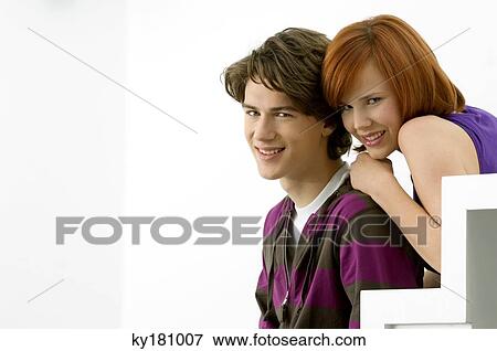 Stock Photo - Portrait of a teenage boy sitting on steps with a young woman and smiling. Fotosearch