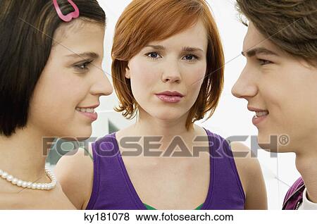 Side profile of a teenage boy smiling with two young women View Large Photo Image Stock Photo - Side profile of a teenage boy smiling with two young women. Fotosearch