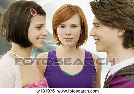 Side profile of a teenage boy smiling with two young women View Large Photo Image Stock Photograph - Side profile of a teenage boy smiling with two young women. Fotosearch