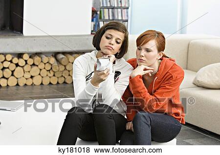 Two young women holding a change purse and looking sad View Large Photo Image Stock Photo - Two young women holding a change purse and looking sad. Fotosearch