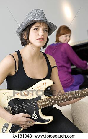 Young woman playing a guitar View Large Photo Image Stock Image - Young woman playing a guitar. Fotosearch