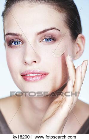 Stock Image - Young woman applying foundation. Fotosearch