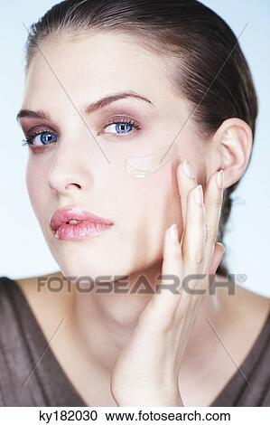 Stock Image - Young woman applying foundation. Fotosearch