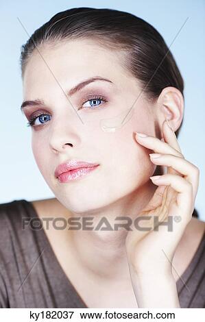 Young woman applying foundation View Large Photo Image Stock Photo - Young woman applying foundation. Fotosearch