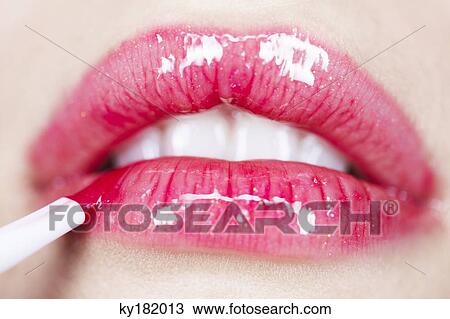Young woman applying lipstick, close-up View Large Photo Image Stock Image - Young woman applying lipstick, close-up. Fotosearch