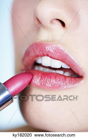 Young woman applying lipstick, close-up View Large Photo Image Stock Image - Young woman applying lipstick, close-up. Fotosearch