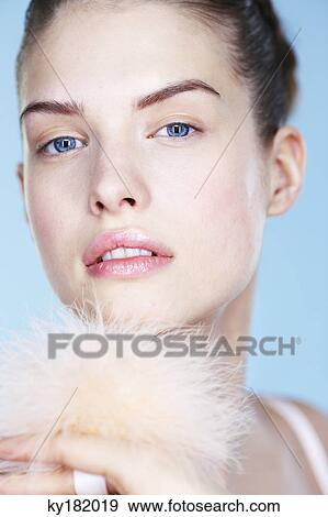 Stock Photo - Young woman holding powder puff. Fotosearch