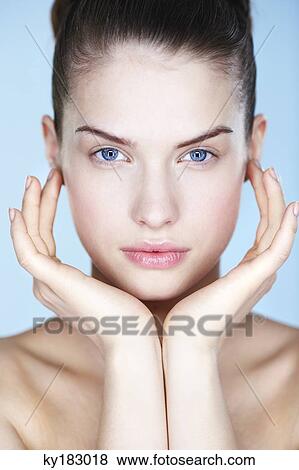 Portrait of young woman with hands on cheeks View Large Photo Image Stock Photo - Portrait of young woman with hands on cheeks. Fotosearch