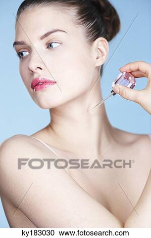 Young woman applying perfume View Large Photo Image Stock Image - Young woman applying perfume. Fotosearch