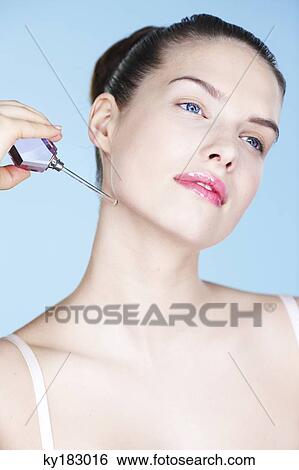 Young woman applying perfume View Large Photo Image Stock Photograph - Young woman applying perfume. Fotosearch