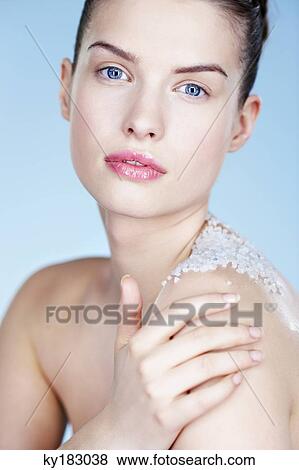 Stock Photo - Young woman rubbing her shoulder with salt. Fotosearch