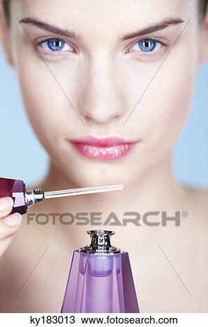 Young woman smelling perfume View Large Photo Image Stock Image - Young woman smelling perfume. Fotosearch