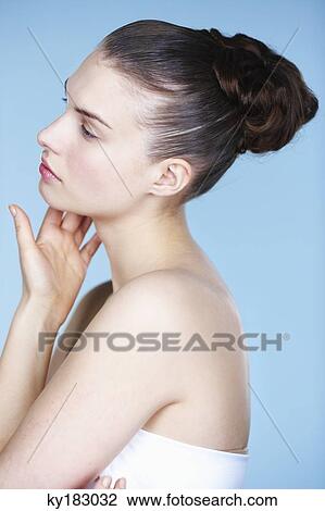 Young woman touching her cheek, side view View Large Photo Image Stock Image - Young woman touching her cheek, side view. Fotosearch