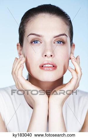 Young woman with hands on cheeks View Large Photo Image Stock Image - Young woman with hands on cheeks. Fotosearch