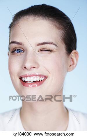 Stock Image - Portrait of young woman winking. Fotosearch