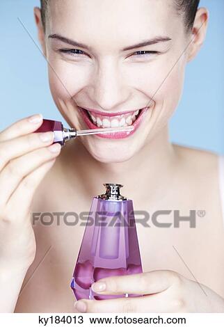 Young woman smelling perfume View Large Photo Image Stock Image - Young woman smelling perfume. Fotosearch
