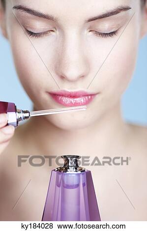 Stock Photo - Young woman smelling perfume. Fotosearch
