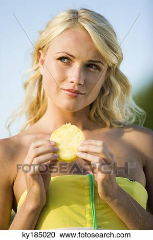 Portrait of a young blond woman eating pineapple slice View Large Photo Image Stock Image - Portrait of a young blond woman eating pineapple slice. Fotosearch