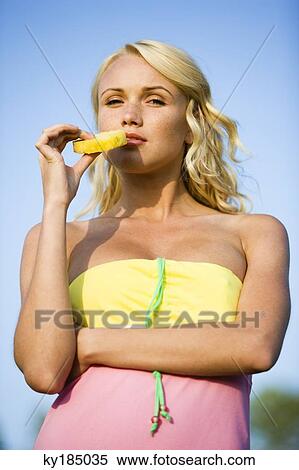 Portrait of a young blond woman eating pineapple slice View Large Photo Image Stock Photography - Portrait of a young blond woman eating pineapple slice. Fotosearch