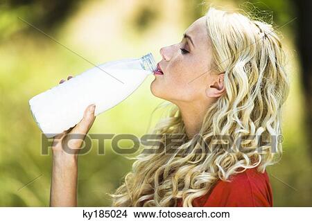 Young woman drinking milk from the bottle View Large Photo Image Picture - Young woman drinking milk from the bottle. Fotosearch