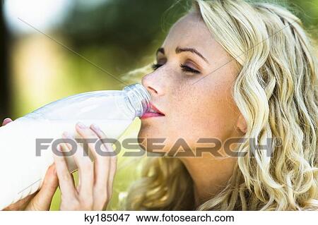 Young woman drinking milk from the bottle View Large Photo Image Stock Photo - Young woman drinking milk from the bottle. Fotosearch