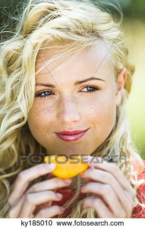Young woman eating an yellow tomato View Large Photo Image Stock Image - Young woman eating an yellow tomato. Fotosearch