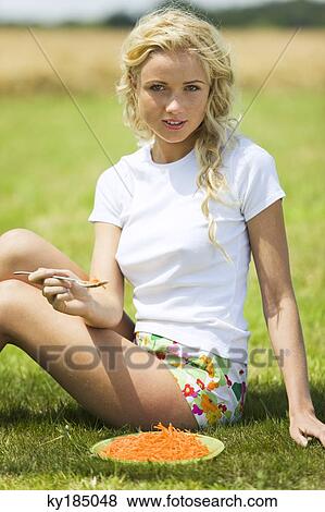 Young woman eating grated carrots View Large Photo Image Stock Photo - Young woman eating grated carrots. Fotosearch