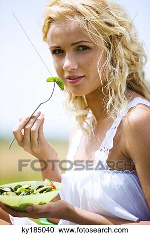Young woman eating vegetables View Large Photo Image Stock Image - Young woman eating vegetables. Fotosearch