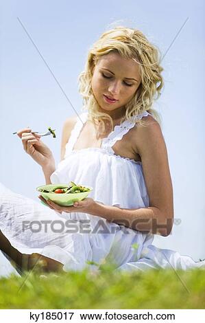 Young woman eating vegetables View Large Photo Image Stock Photo - Young woman eating vegetables. Fotosearch