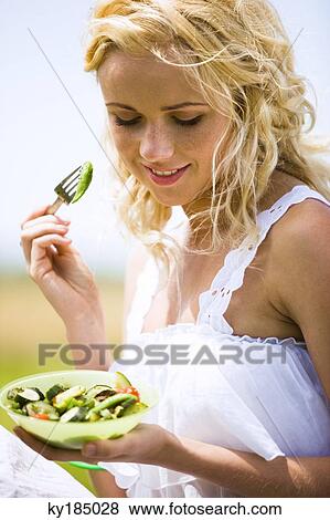 Young woman eating vegetables View Large Photo Image Stock Photo - Young woman eating vegetables. Fotosearch