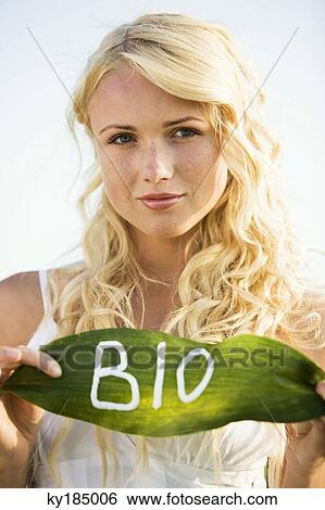 Young woman holding a leaf with "BIO" lettering View Large Photo Image Stock Photograph - Young woman holding a leaf with "BIO" lettering. Fotosearch