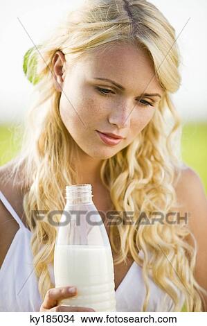 Young woman holding a milk bottle View Large Photo Image Picture - Young woman holding a milk bottle. Fotosearch