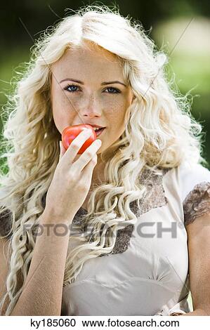 Young woman holding a tomato View Large Photo Image Stock Image - Young woman holding a tomato. Fotosearch