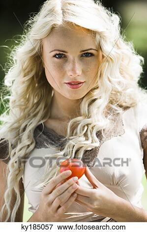 Stock Photo - Young woman holding a tomato. Fotosearch