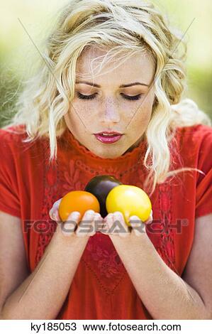 Young woman holding three colored tomatoes View Large Photo Image Stock Image - Young woman holding three colored tomatoes. Fotosearch