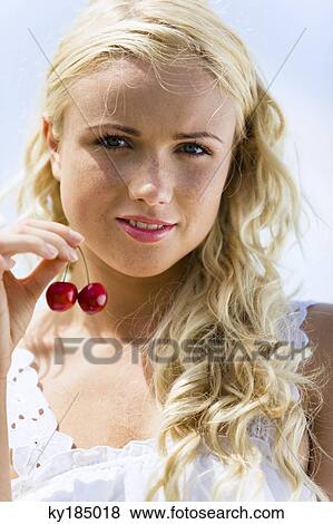 Young woman holding two cherries View Large Photo Image Stock Photo - Young woman holding two cherries. Fotosearch