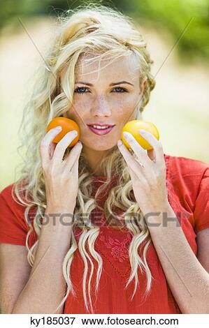 Young woman holding two tomatoes View Large Photo Image Stock Photo - Young woman holding two tomatoes. Fotosearch