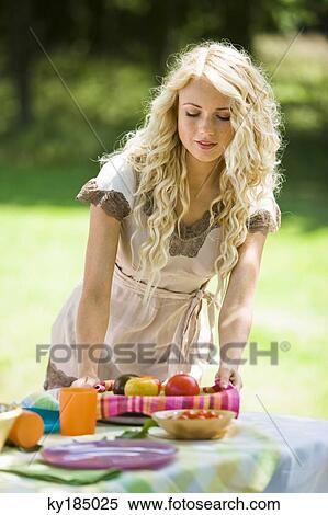 Young woman setting table outdoors View Large Photo Image Stock Photography - Young woman setting table outdoors. Fotosearch