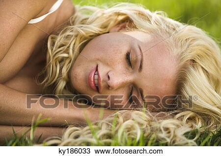 Stock Image - Portrait of young woman lying. Fotosearch