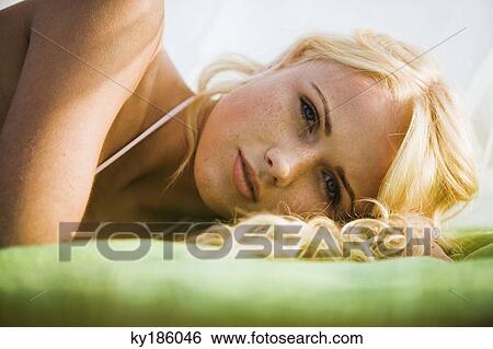 Stock Photograph - Portrait of young woman lying. Fotosearch
