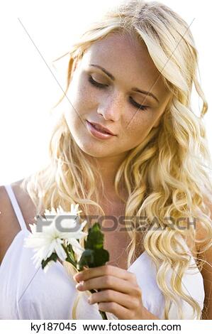 Stock Photography - Portrait of a young woman holding a white flower. Fotosearch