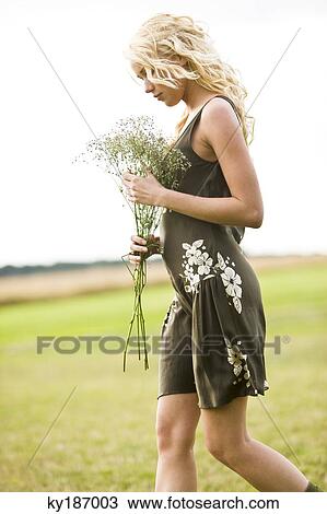 Stock Image - Young woman holding a bunch of flowers. Fotosearch