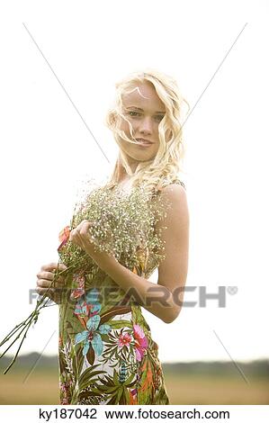 Young woman holding a bunch of flowers View Large Photo Image Stock Image - Young woman holding a bunch of flowers. Fotosearch