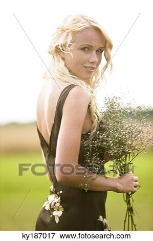 Young woman holding a bunch of flowers View Large Photo Image Stock Photo - Young woman holding a bunch of flowers. Fotosearch