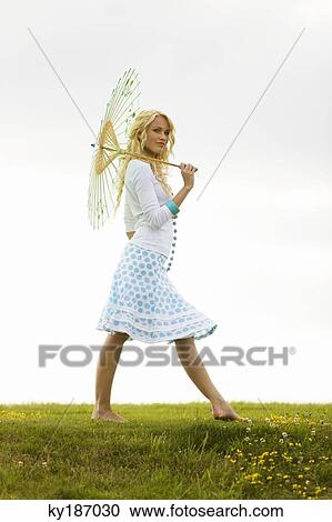 Young woman holding an umbrella View Large Photo Image Stock Image - Young woman holding an umbrella. Fotosearch