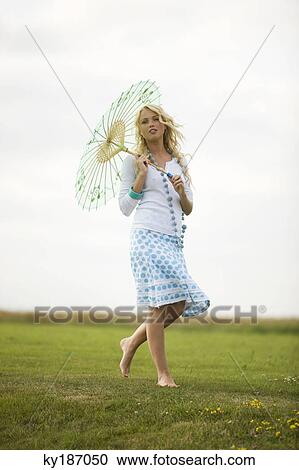 Young woman holding an umbrella View Large Photo Image Stock Image - Young woman holding an umbrella. Fotosearch