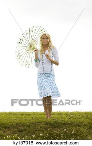 Young woman holding an umbrella View Large Photo Image Stock Photo - Young woman holding an umbrella. Fotosearch